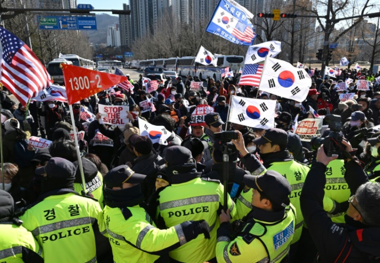 Supporters of impeached President Yoon Suk Yeol wave South Korea and the US flags as they gather outsidethe Corruption Investigation Office