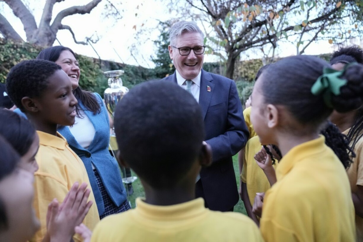 Britain's Prime Minister Keir Starmer (C) and Culture Secretary Lisa Nandy (back L) meet children at 10 Downing Street during a visit by UEFA officials to mark the launch of Euro 2028