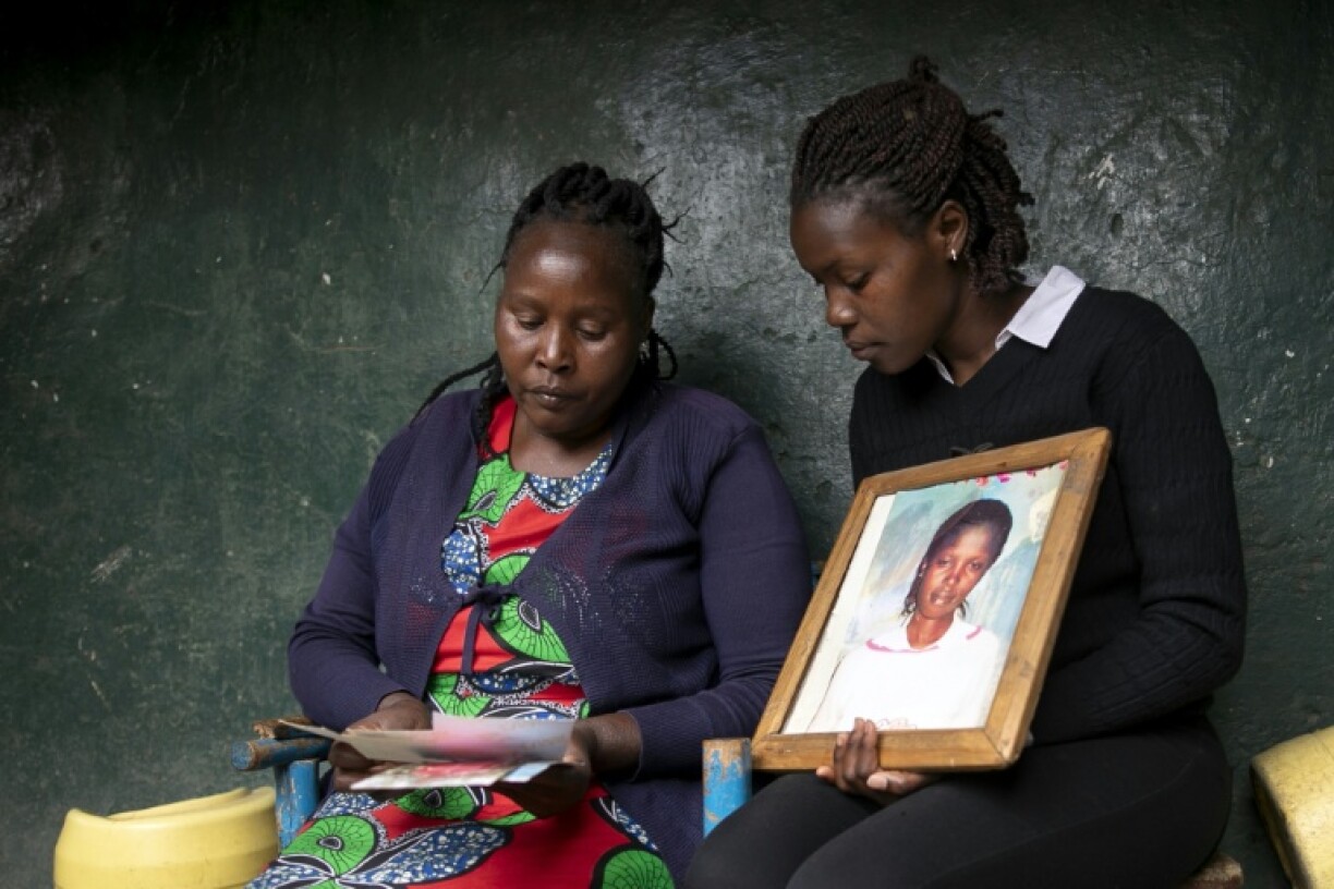 Agnes Wanjiru's sister Rose and another relative hold a picture of the young mother, who was found dead in 2012