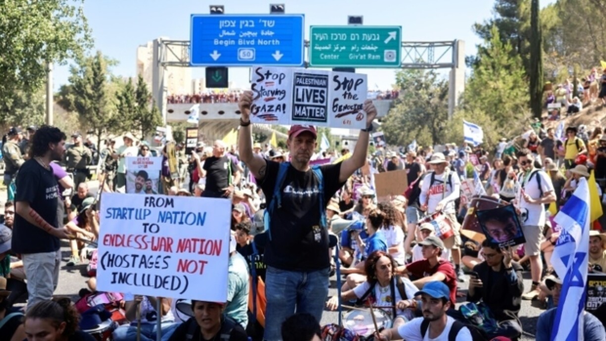 Des familles d'otages retenus dans la bande de Gaza et personnes les soutenant brandissent des panneaux et drapeaux israéliens lors d'une manifestation appelant à les libérer, à Jérusalem, le 17 août 2025