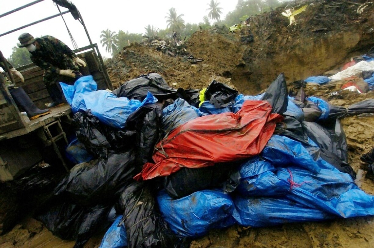 Indonesian soldiers unload bodies of tsunami disaster victims at a mass grave in Banda Aceh, January 13, 2005