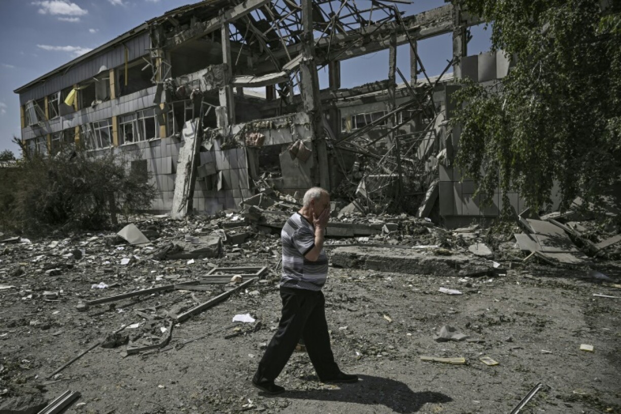 Un homme passe devant une école détruite par un bombardement à Bakhmut, dans l'est de l'Ukraine, le 8 juin 2022
