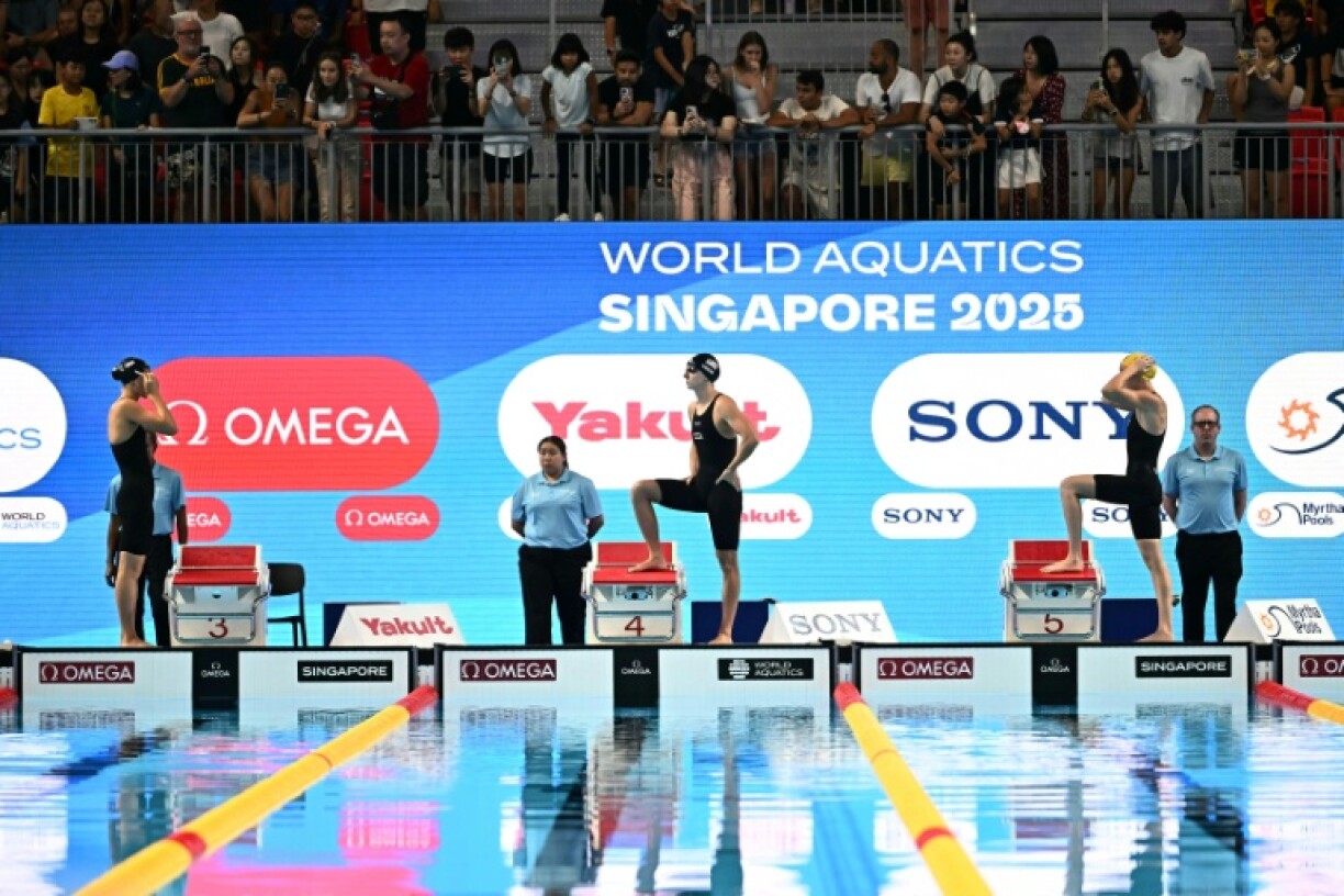 (L-R) Canada's swimmer Summer Mcintosh, US' swimmer Katie Ledecky and Australia's swimmer Lani Pallister arrive for the final of the women's 800m freestyle