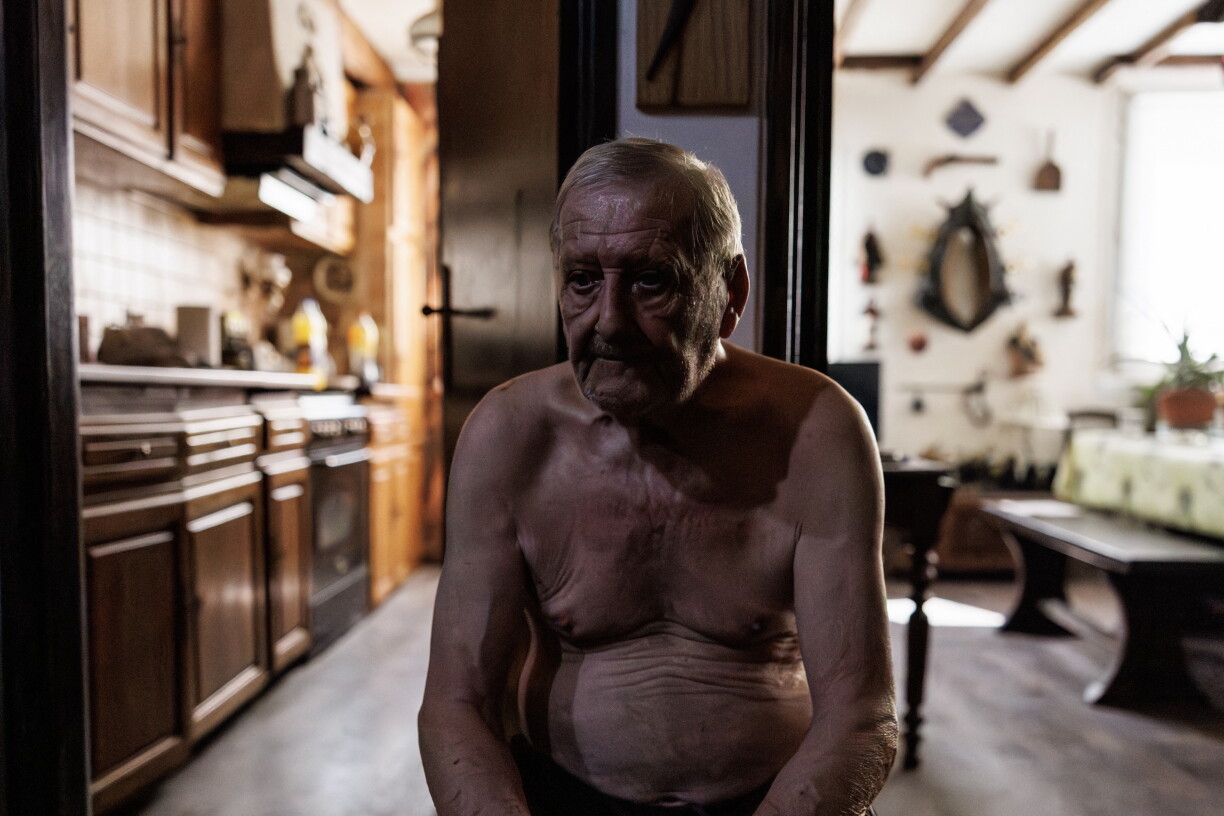 Daniel Molignier, 80 ans, est assis dans l'entrée de son appartement pour échapper à la chaleur du salon, dans son appartement de la place des Fêtes, lors d'une chaude journée d'été à Paris. C'était le 29 juillet 2026.