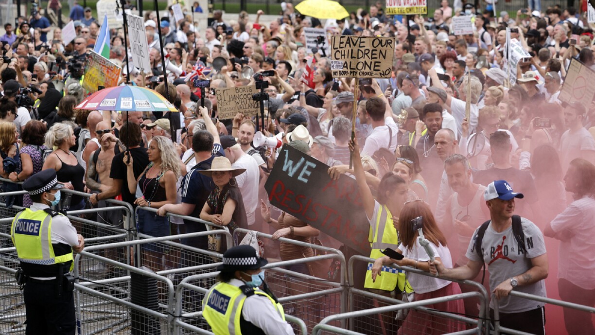 Protesters hold up placards at a gathering outside Downing Street as they demonstrate against government lockdown restrictions, 5G and covid-19 vaccinations in central London on June 14, 2021.