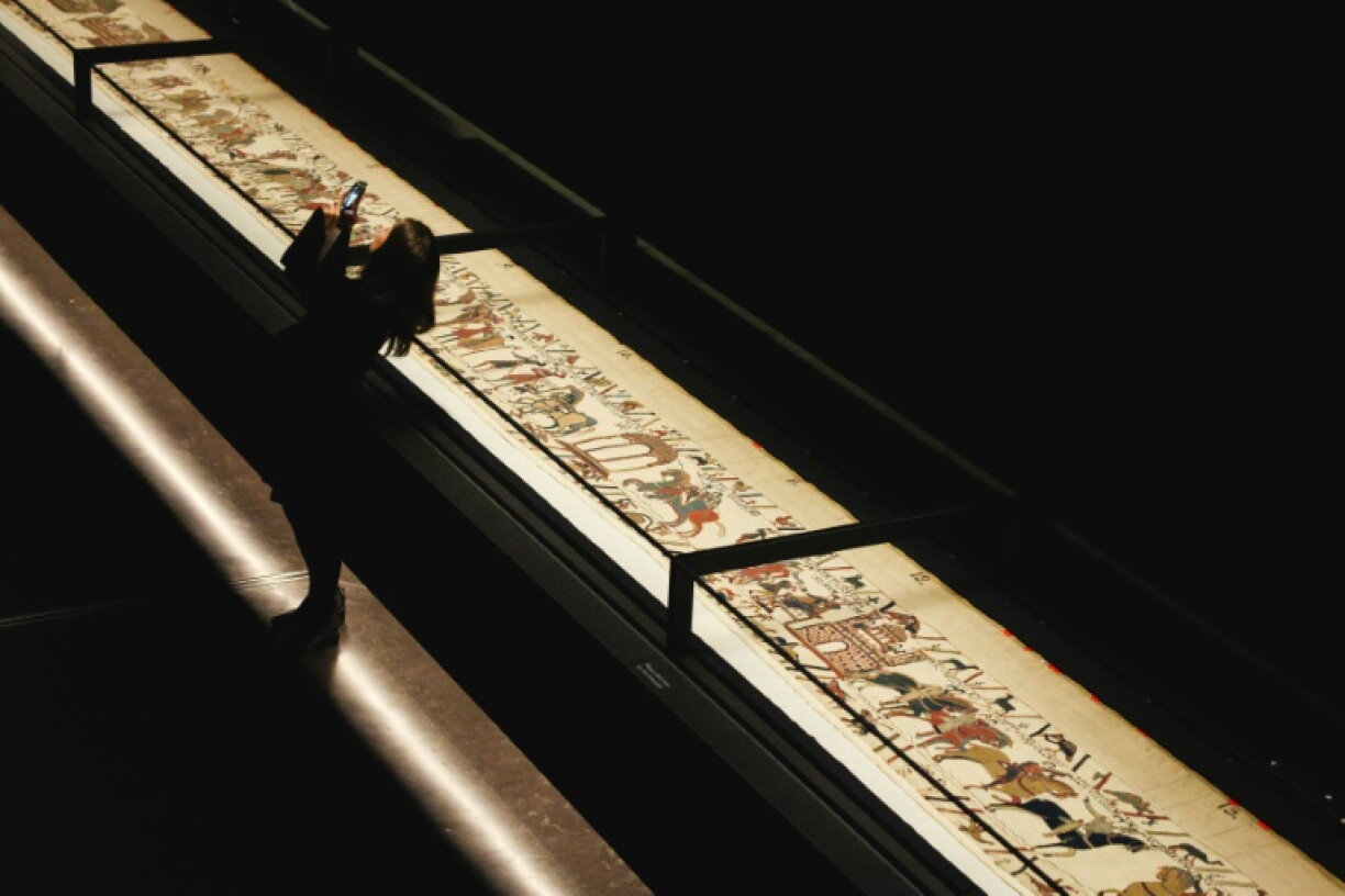 A person takes a selfie with the Bayeux Tapestry exhibited at the British Museum in central London on a loan from France until July