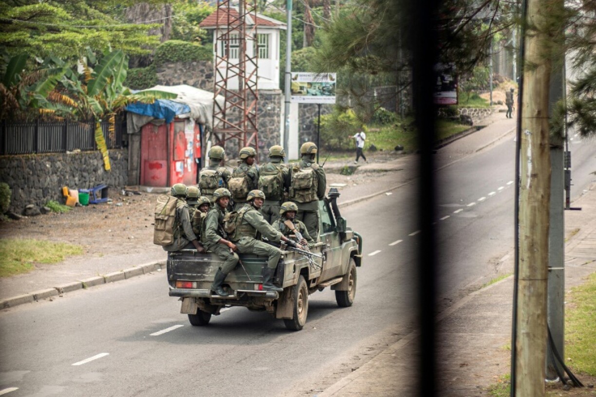 Armed men travel in an unmarked pickup truck through the streets of Goma