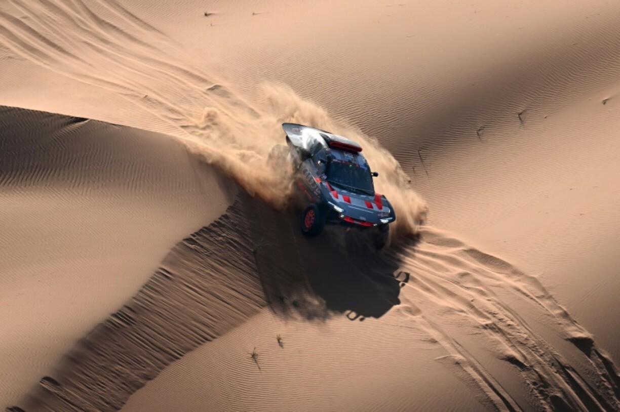 La Audi hybvride pilotée par l'Espagnol Carlos Sainz et copilotée par son compatriote Lucas Cruz au milieu des dunes du Dakar le 12 janvier 2024 entre Shubaytah et Shubaytah