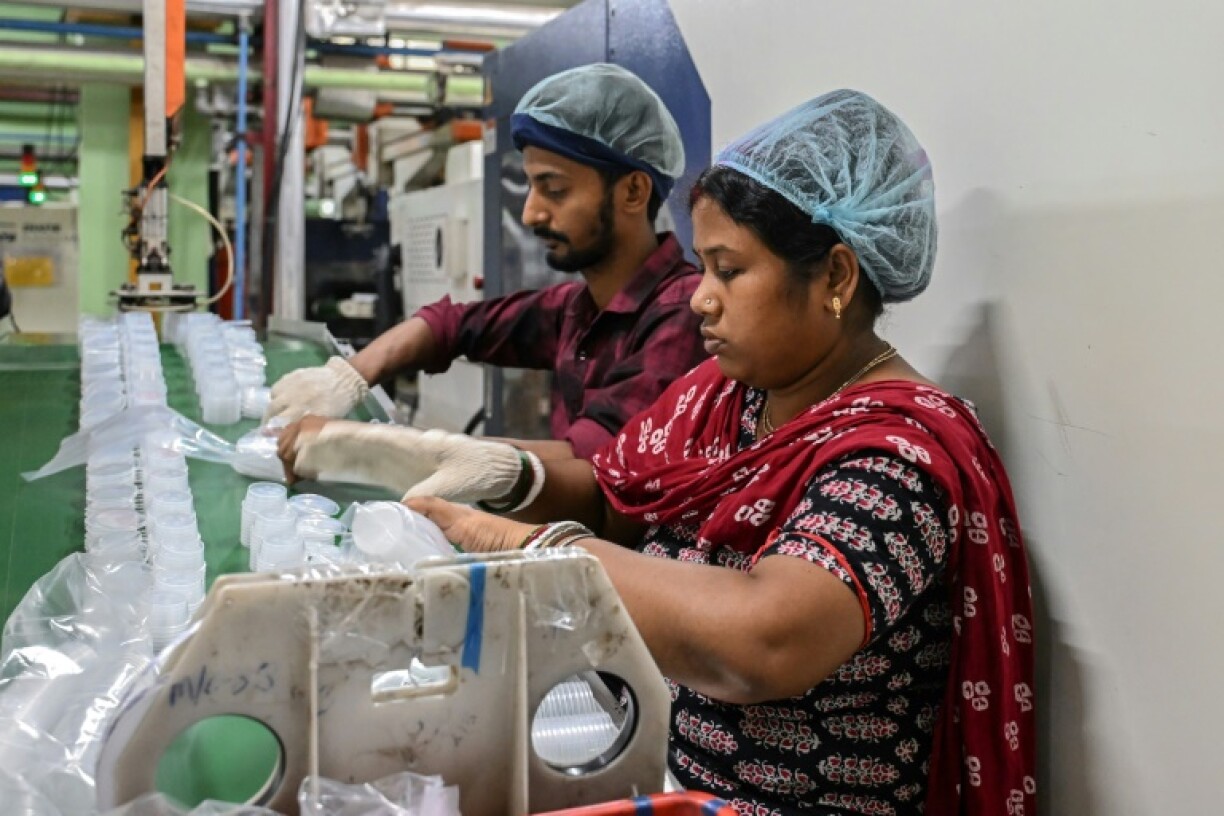 Workers pack food containers made with virgin plastics at a factory on the outskirts of Kolkata, India