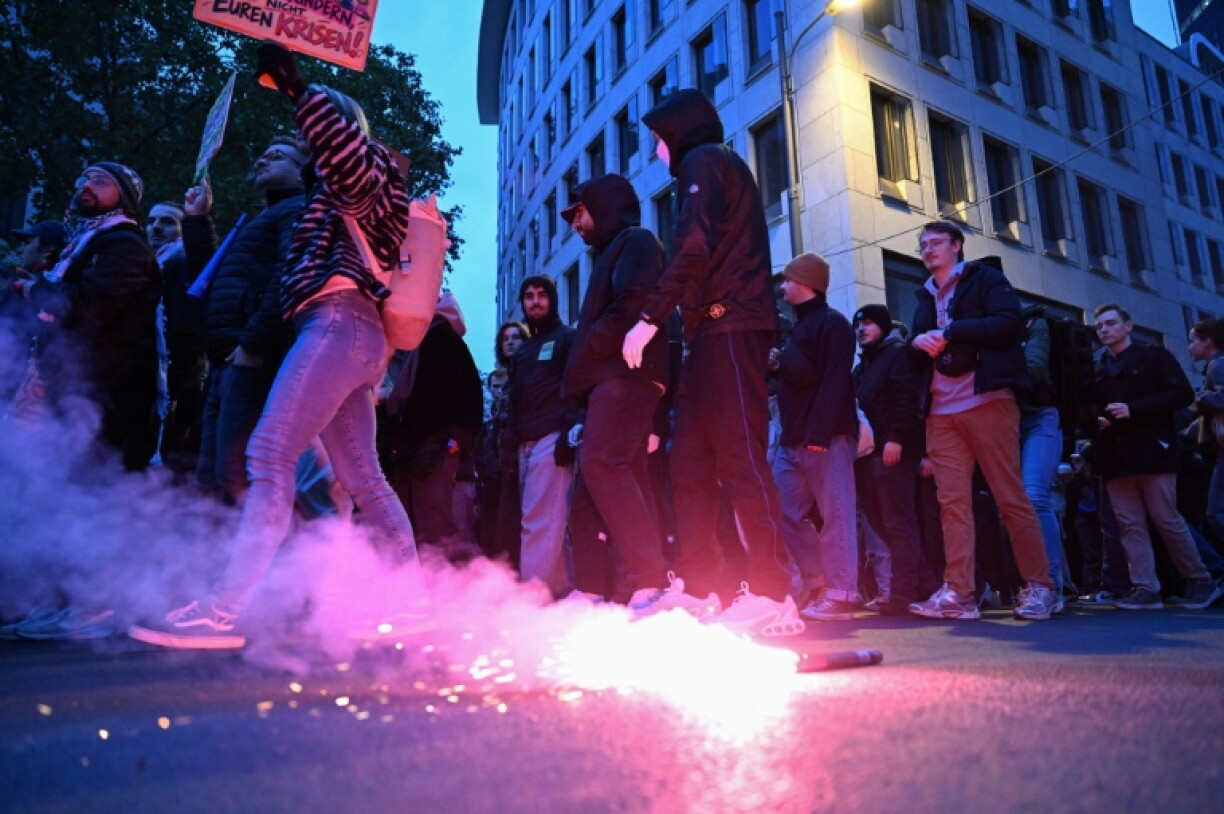 Protesters light flares during a demonstration in the German city of Frankfurt