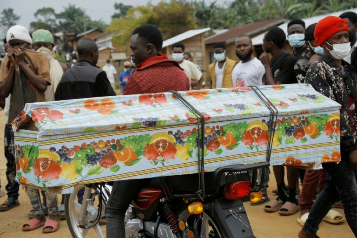 A man carries away a coffin loaded on the back of his motorcycle