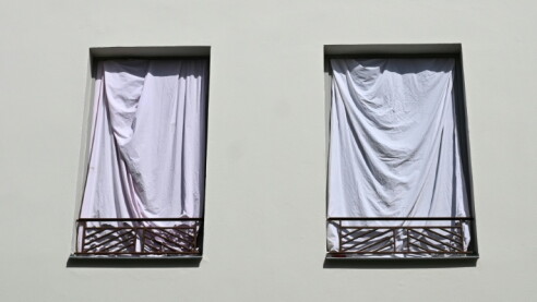 Windows covered by sheets in a bid to block sunlight in Nantes, western France