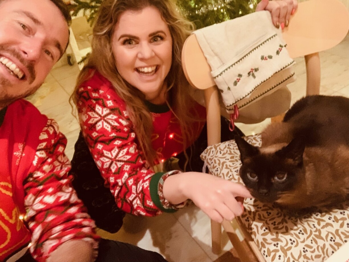 Reader Cara Furniss and unnamed male compatriot (we don't want to assume what their relationship might be - but feel free to let your imagination run wild) and her (we pressume, but cannot know for certain) cat (this is certain) enjoying Christmas.