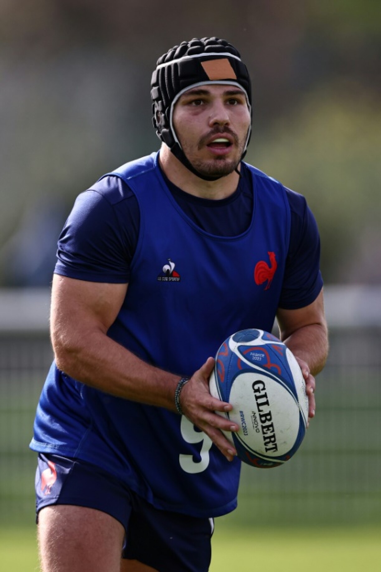 Antoine Dupont, ballon en mains et avec son casque à l'entraînement au stade du Parc de Rueil-Malmaison près de Paris le 11 octobre 2023