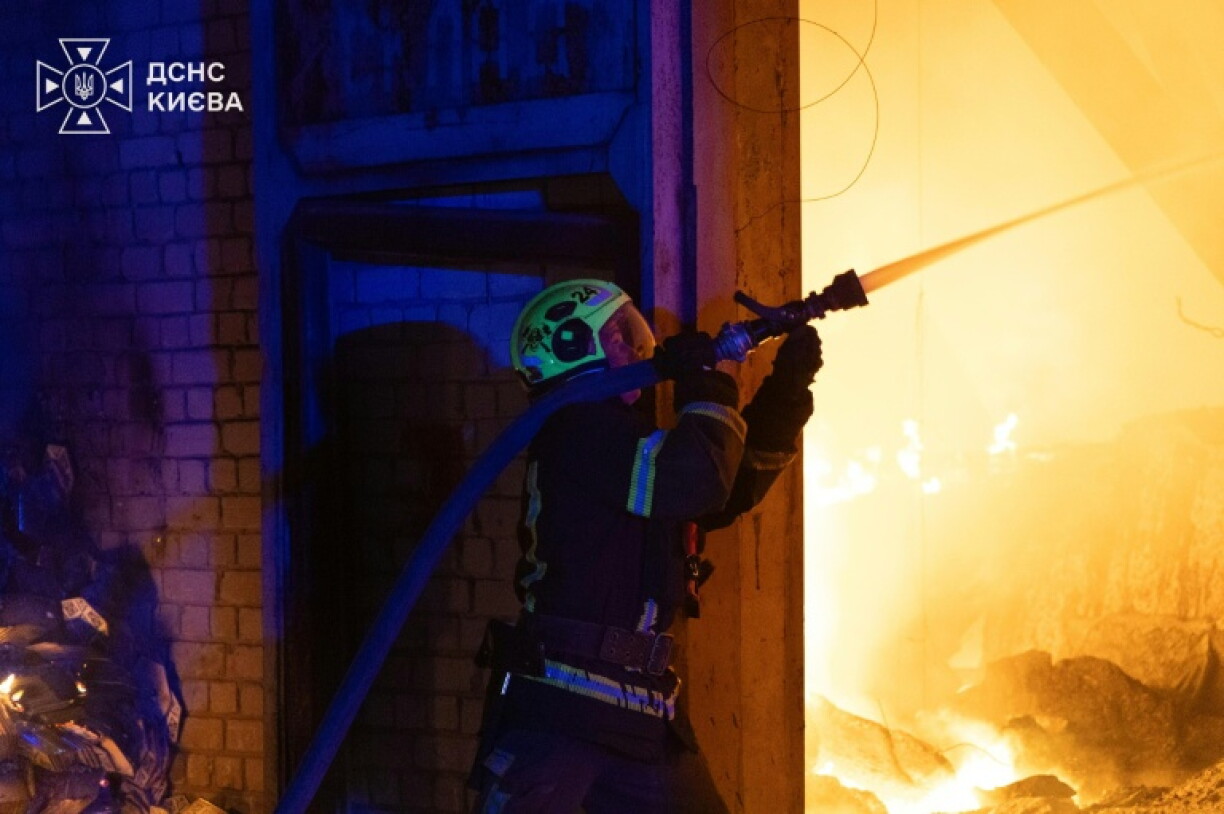 Photo prise et diffusée le 8 août 2026 par le service d’État ukrainien des situations d’urgence montrant un pompier luttant contre un incendie après des frappes de missiles balistiques russes à Kiev