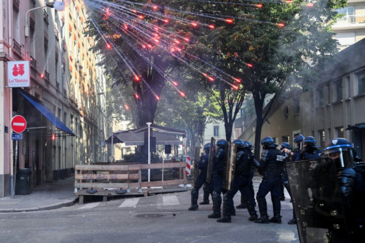 Des policiers anti-émeutes sont rassemblés alors que des feux d'artifice éclatent au-dessus d'eux, lors d'une manifestation de lycéens aux côtés d'un syndicat d'enseignants à Lyon, dans le Rhône, le 6 octobre 2026