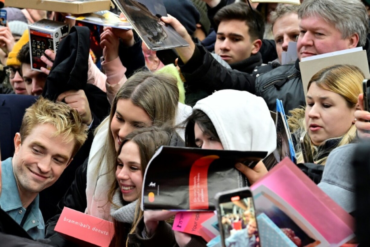 English actor Robert Pattinson poses for a selfie after a press conference for the film