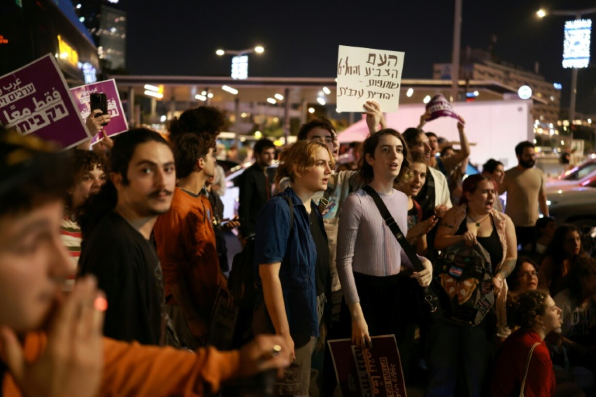 Israeli left-wing activists in Tel Aviv hold placards during a protest calling for a formation of a government together with Arab parties