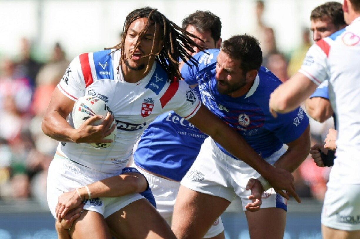 England’s Dominic Young (L) is tackled during the Rugby League World Cup match against France