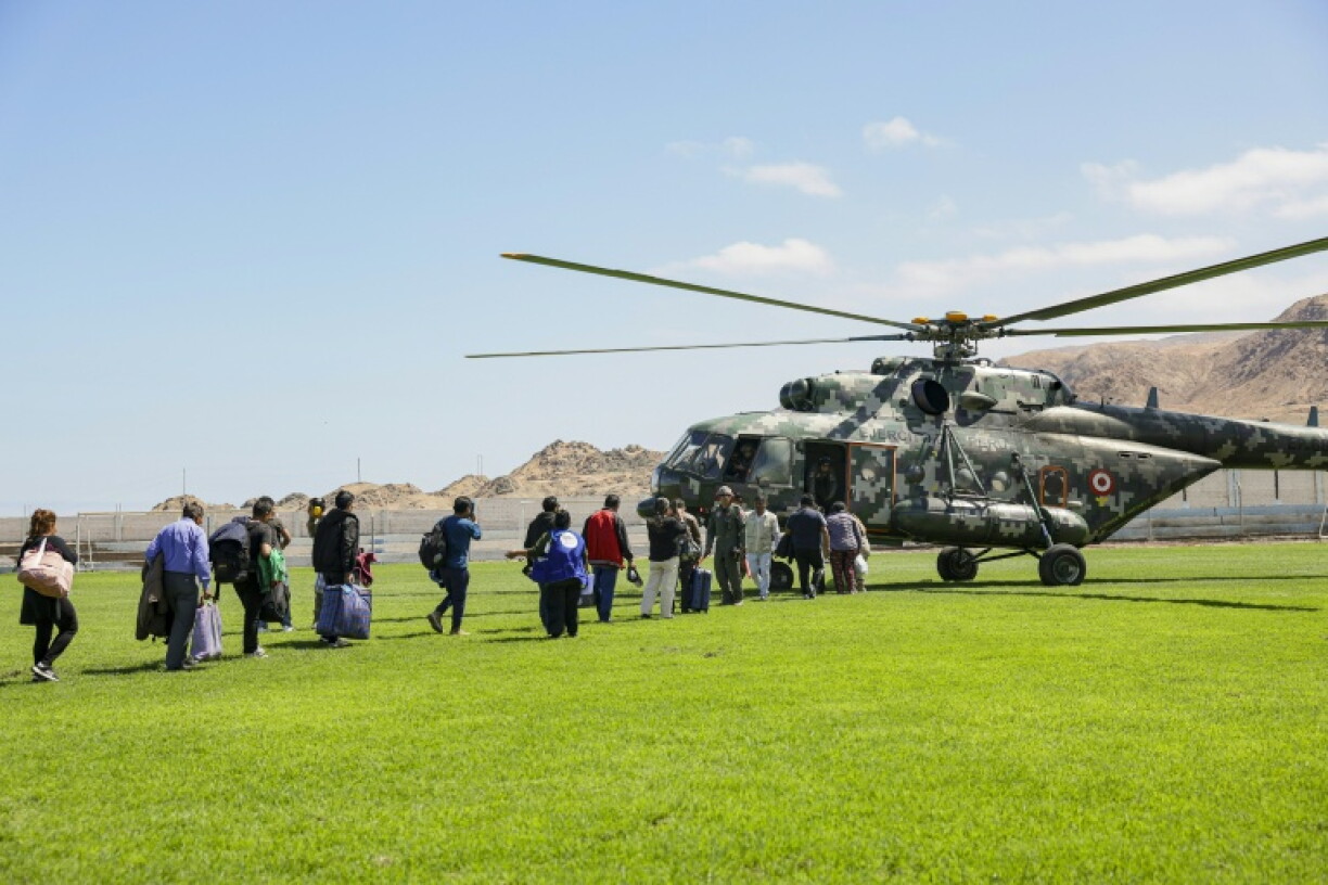 Des personnes sont transportées à bord d'un hélicoptère militaire près du site d'une coulée de boue provoquée par de fortes pluies sur la route panaméricaine entre Atico et Ocoña, dans le département d'Arequipa, dans le sud du Pérou, le 21 août 2026