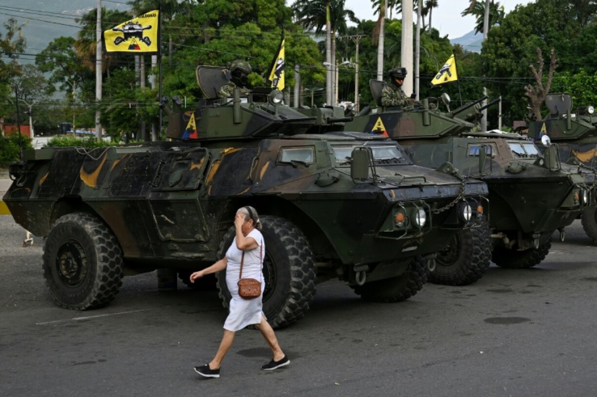 Une femme passe devant des véhicules militaires colombiens stationnés à Cucuta, à la frontière avec le Venezuela, le 3 janvier 2026 Des soldats colombiens en faction au point de passsage de Cucuta, à la frontière avec le Venezuela, le 3 janvier 2026