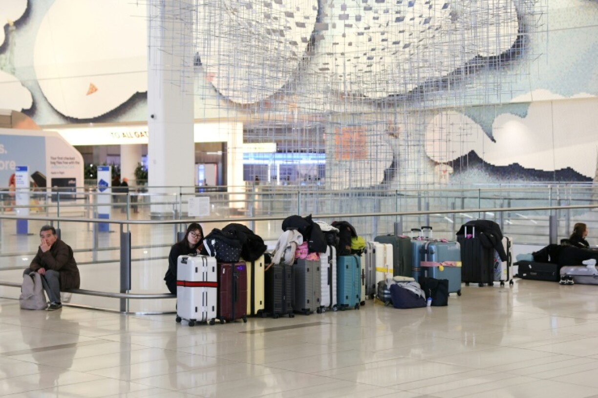 Des passagers en attente le 23 mars 2026 à l'aéroport LaGuardia de New York, fermé après une collision entre un avion et un véhicule de l'autorité portuaire dans la nuit