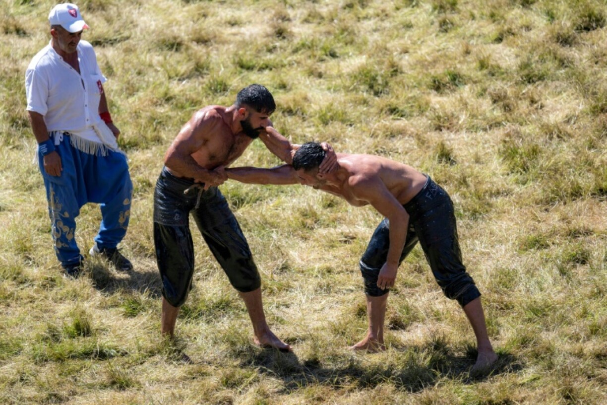 Le lutteur Murat Kalender (g) affronte un concurrent lors du championnat annuel Kirkpinar à Edirne, dans le nord-ouest de la Turquie, le 6 juillet 2024