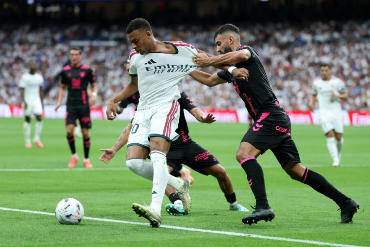 Kylian Mbappe est accroché par Einar Galilea durant le match entre le Real et Malaga, le 30 août 2026 à Madrid