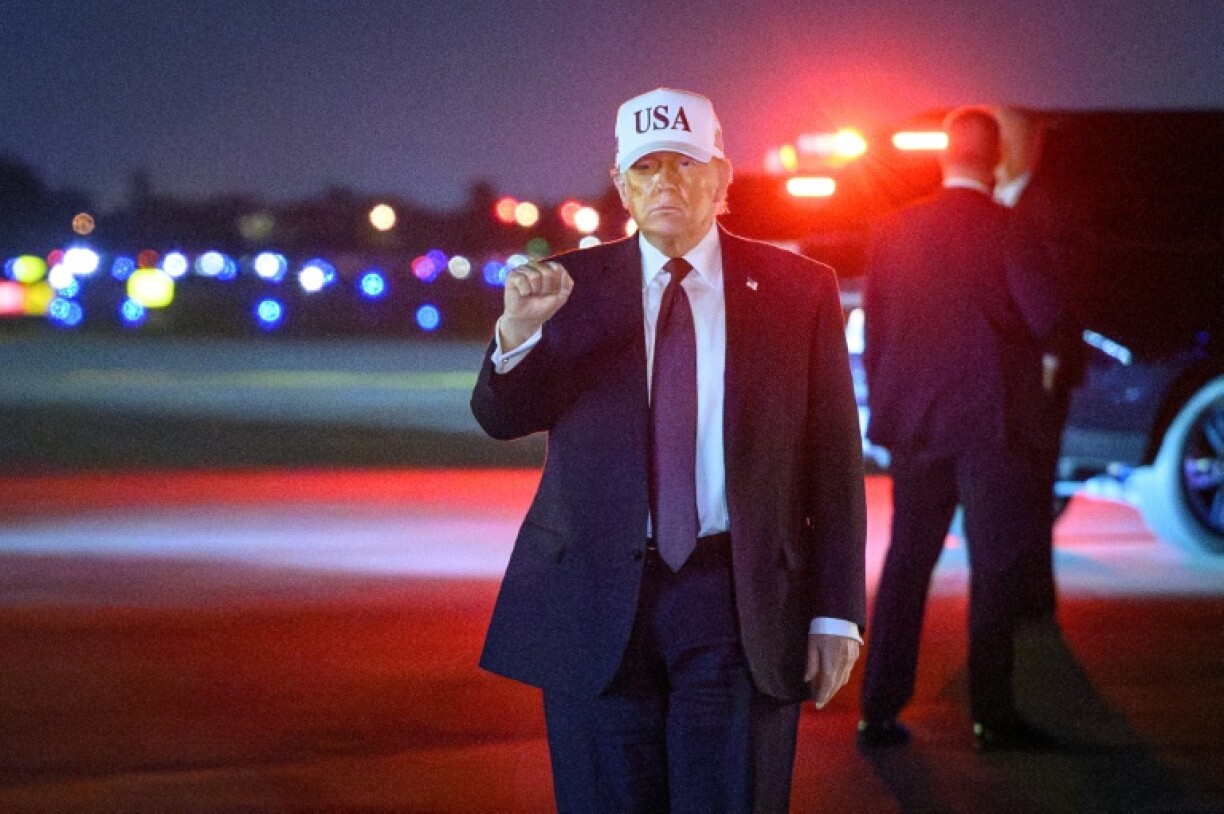 Le président américain Donald Trump gestures à son arrivée à l'aéroport de Palm Beach, en Floride, le 27 février 2026