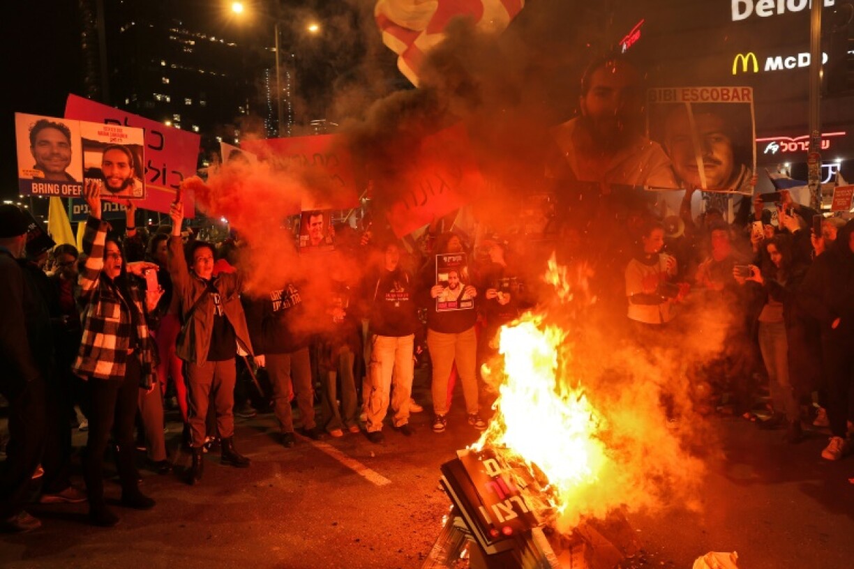 Protesters burn placards during a demonstration calling for the release of hostages held in Gaza