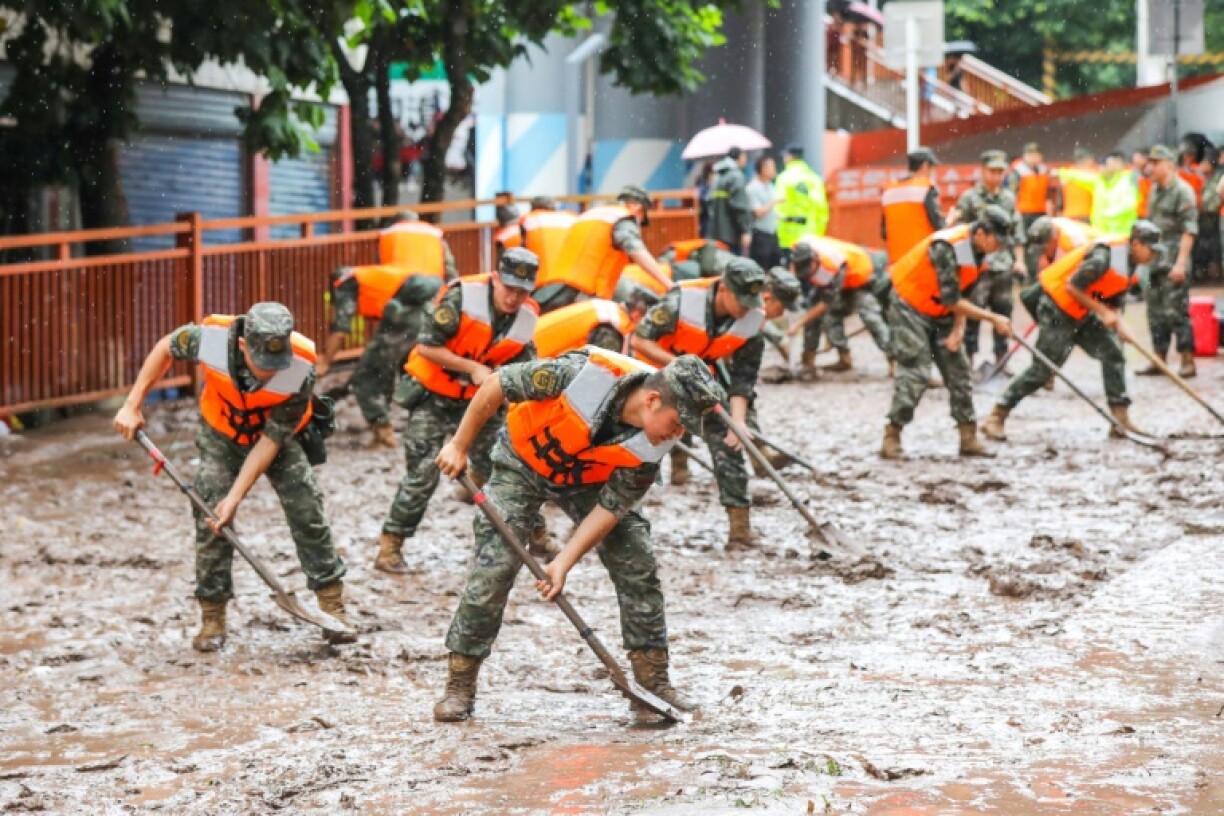 Des policiers nettoient une rue à Chongqing dans le sud-ouest de la Chine le 4 juillet 2023 après des inondations causées par des pluies torrentielles