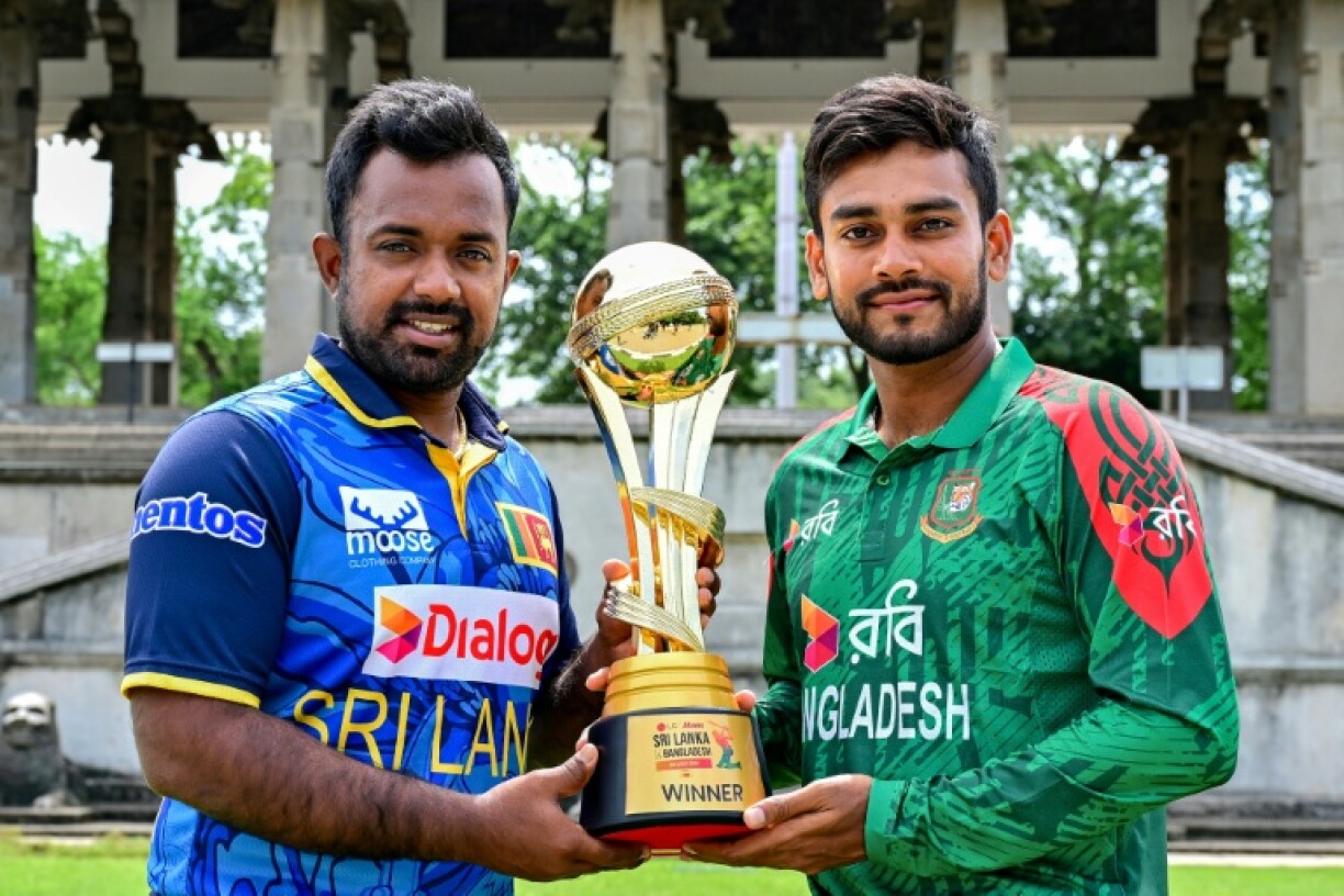 Sri Lanka's captain Charith Asalanka (L) poses with the trophy alongside his Bangladesh counterpart Mehidy Hasan Miraz