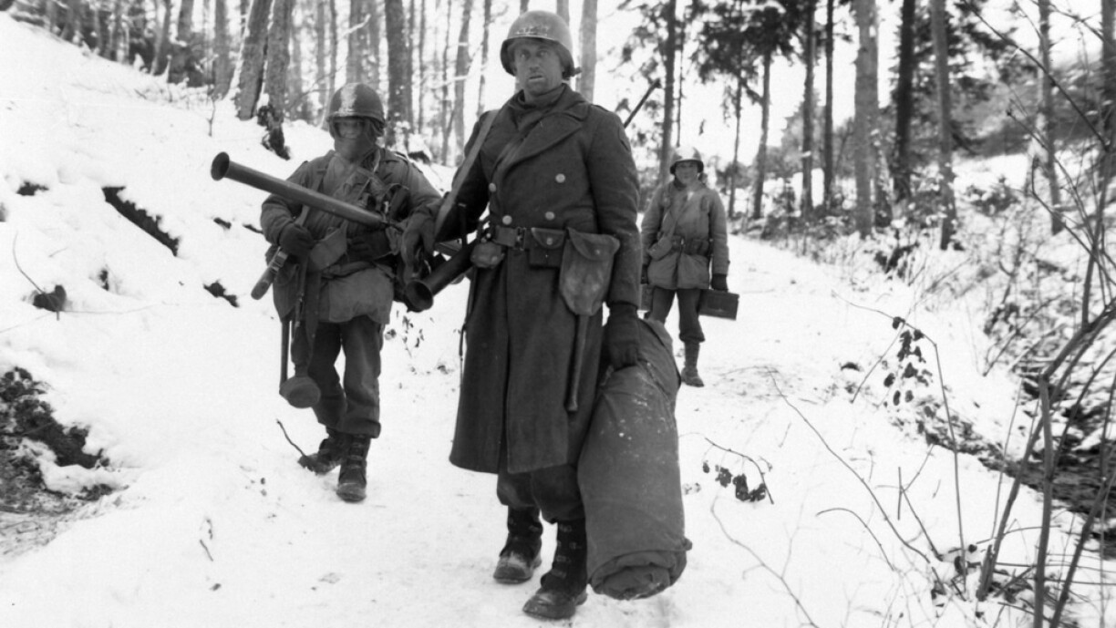 After holding a woodland position all night near Wiltz, Luxembourg, against German counter attack, three men of B Co., 101st Engineers, emerge for a rest. 14 January 1945