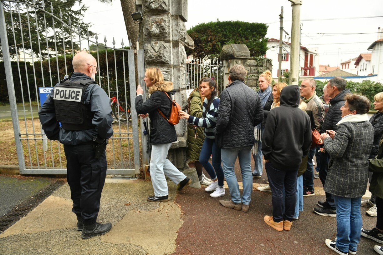 Des personnes réunies devant un établissement scolaire de Saint-Jean-de-Luz, où une enseignante a été poignardée.