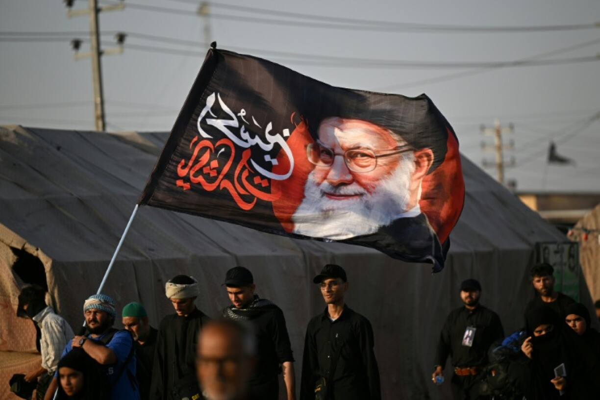 Des pèlerins chiites brandissent un portrait de l'ayatollah Ali Khamenei, le guide suprême iranien tué au début de la guerre, le 19 juin 2026 à Bassorah, en Irak