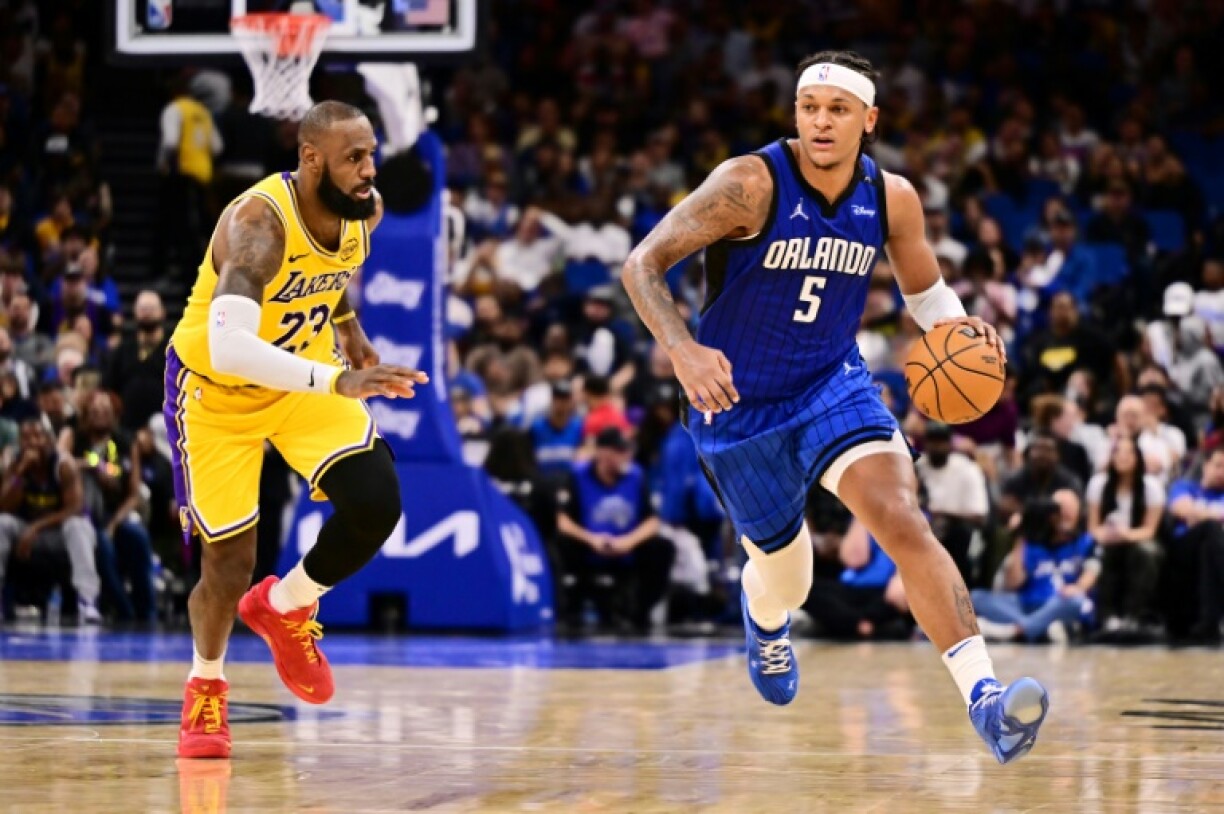Paolo Banchero of the Orlando Magic drives past LeBron James in the Magic's NBA victory over the Los Angeles Lakers