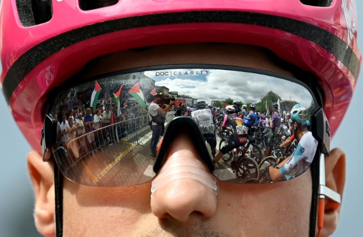 Le face-à-face entre manifestants propalestiniens et coureurs reflêté dans le masque du coureur britannique Lukas Nerurkar au départ de la 15e étape de la Vuelta dimanche à Vegadeo.