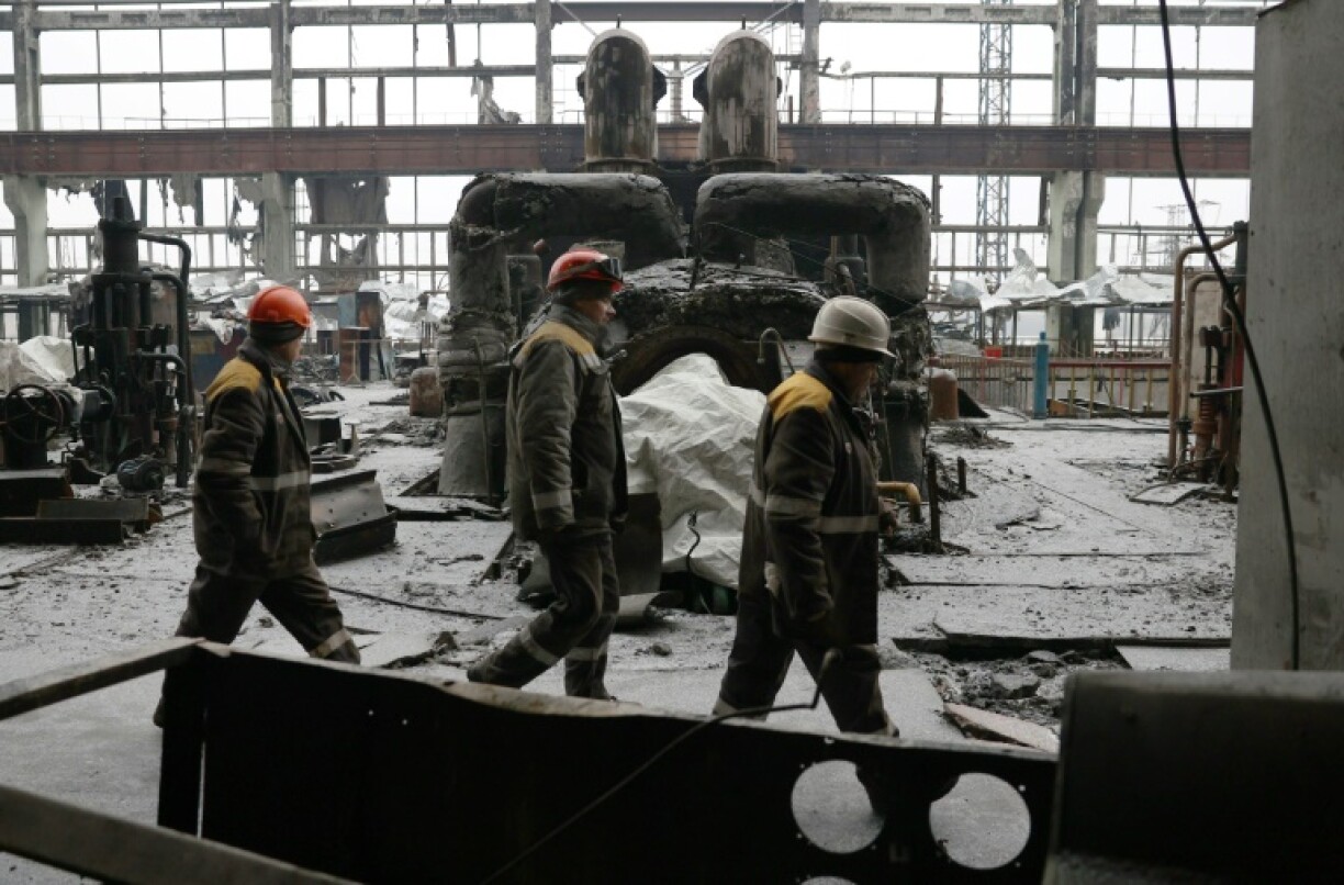 Des travailleurs passent dans une centrale thermique détruite par une attaque de missiles en Ukraine, le 5 décembre 2024.