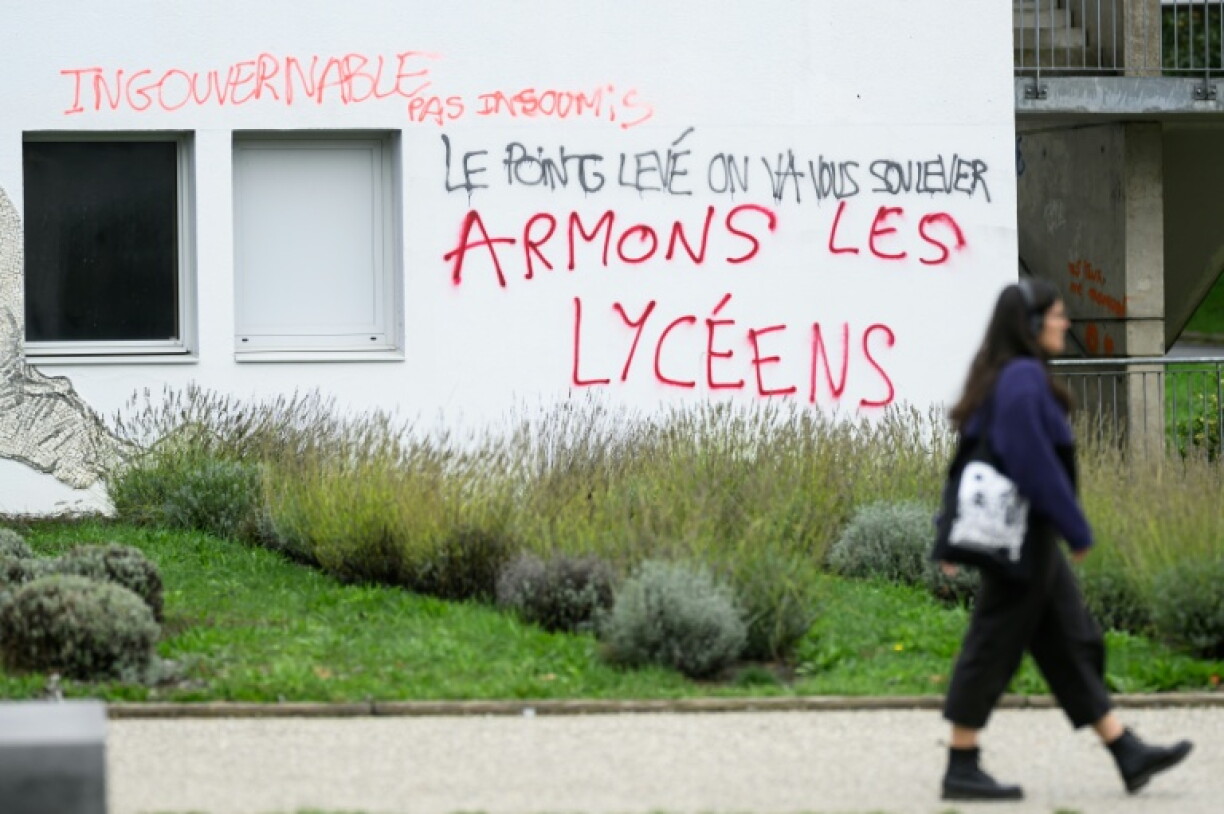 A student passes by a graffiti reading