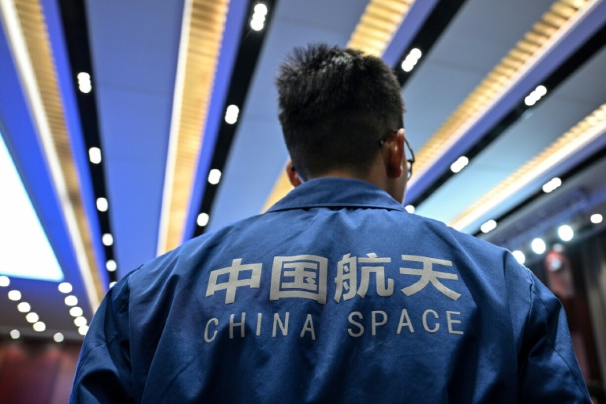 A staff member attends a press conference of the Shenzhou-21 Manned Space Mission one day before the mission's launch