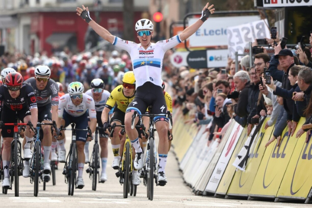 Tim Merlier (C) celebrates as he crosses the finish line at Le Perray-en-Yvelines to win the first stage of Paris-Nice