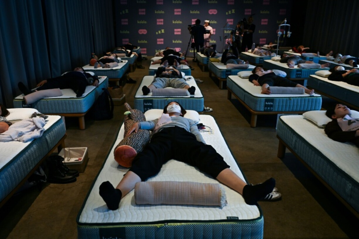 Attendees take part in a sleep competition organised by a mattress brand in Tokyo on October 5, 2026.