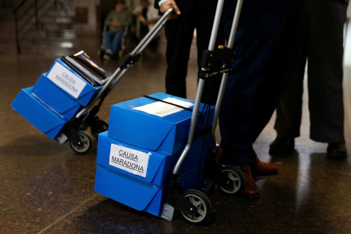 Hand trolleys loaded with boxes reading 'Maradona Case' are moved by the lawyers for Argentina's late football legend Diego Maradona's former nurse, Gisella Dahiana Madrid, who will be tried separately