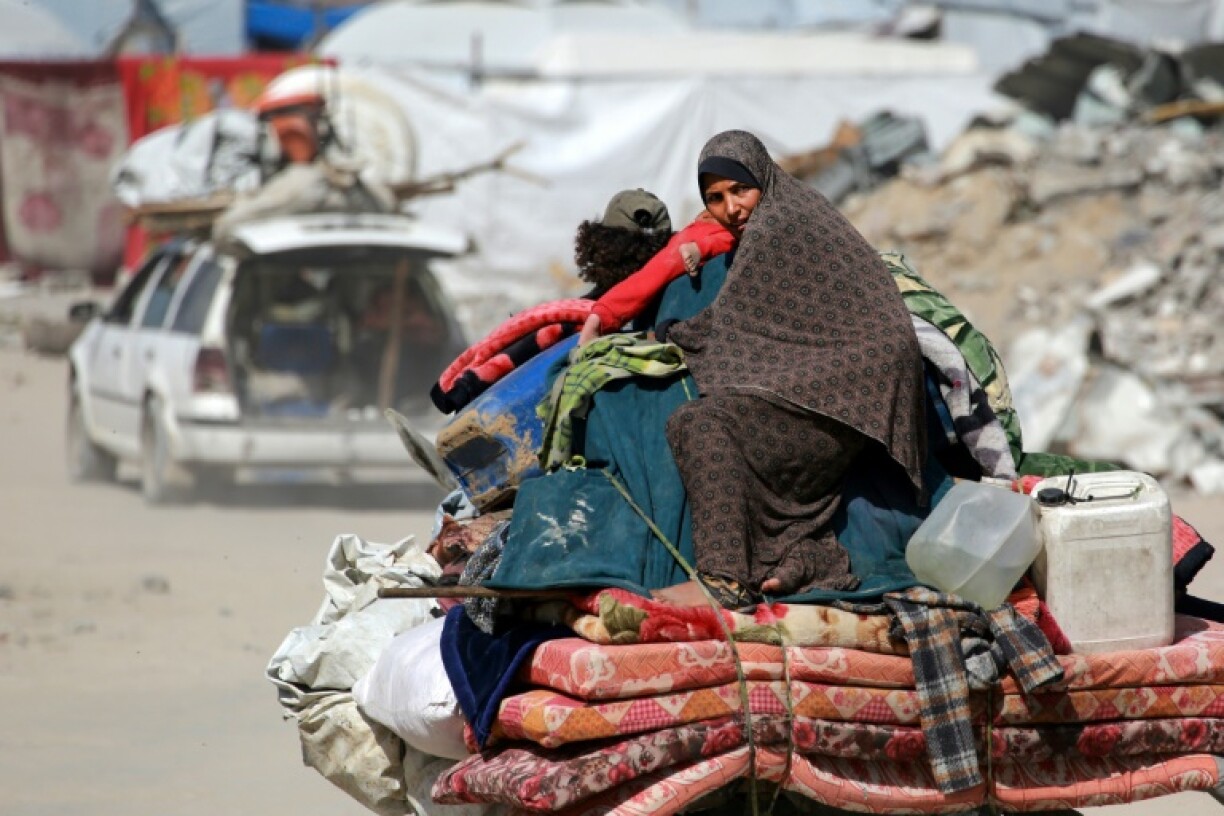 A Palestinian woman sits atop her family belongings as people flee Gaza City