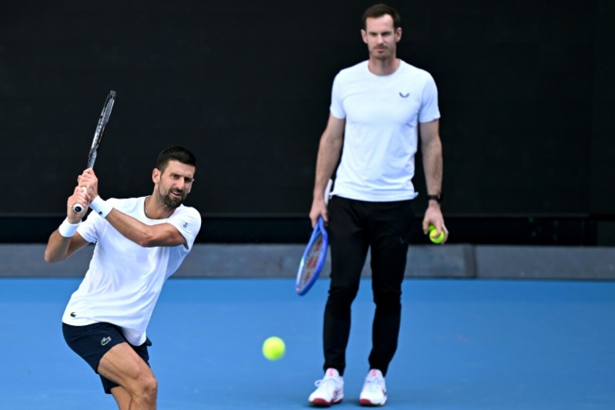 Novak Djokovic hits a return as coach Andy Murray looks on during a training session ahead of the Australian Open