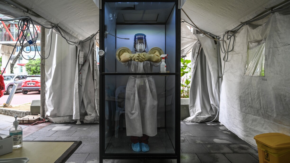 A health worker stands inside a non-contact chamber called the