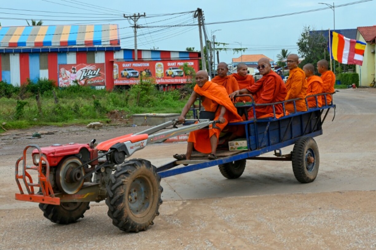 Cambodian Buddhist monks sit on a homemade vehicle in Oddar Meanchey province, as Thai and Cambodian forces clashed for a third day