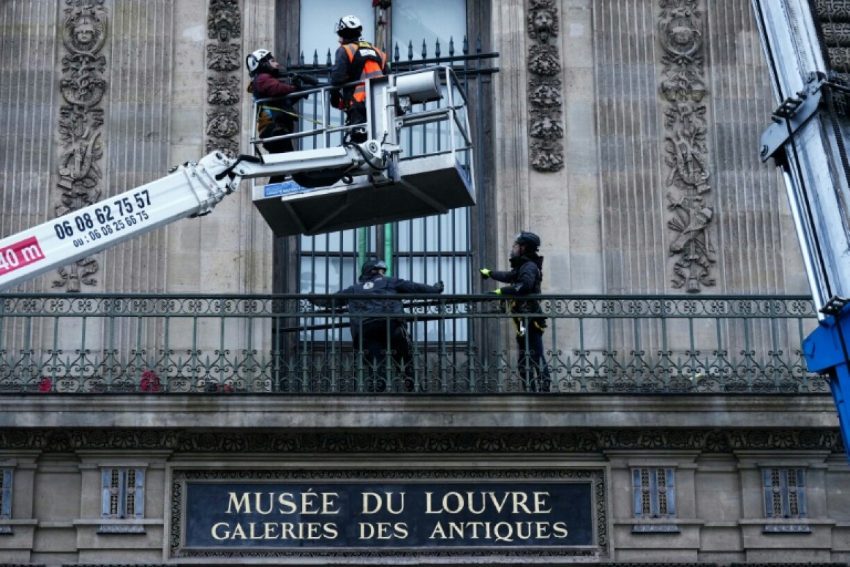 Des ouvriers installent une grille de protection devant la fenêtre de la galerie d'Apollon du musée du Louvre, le 23 décembre 2025 à Paris
