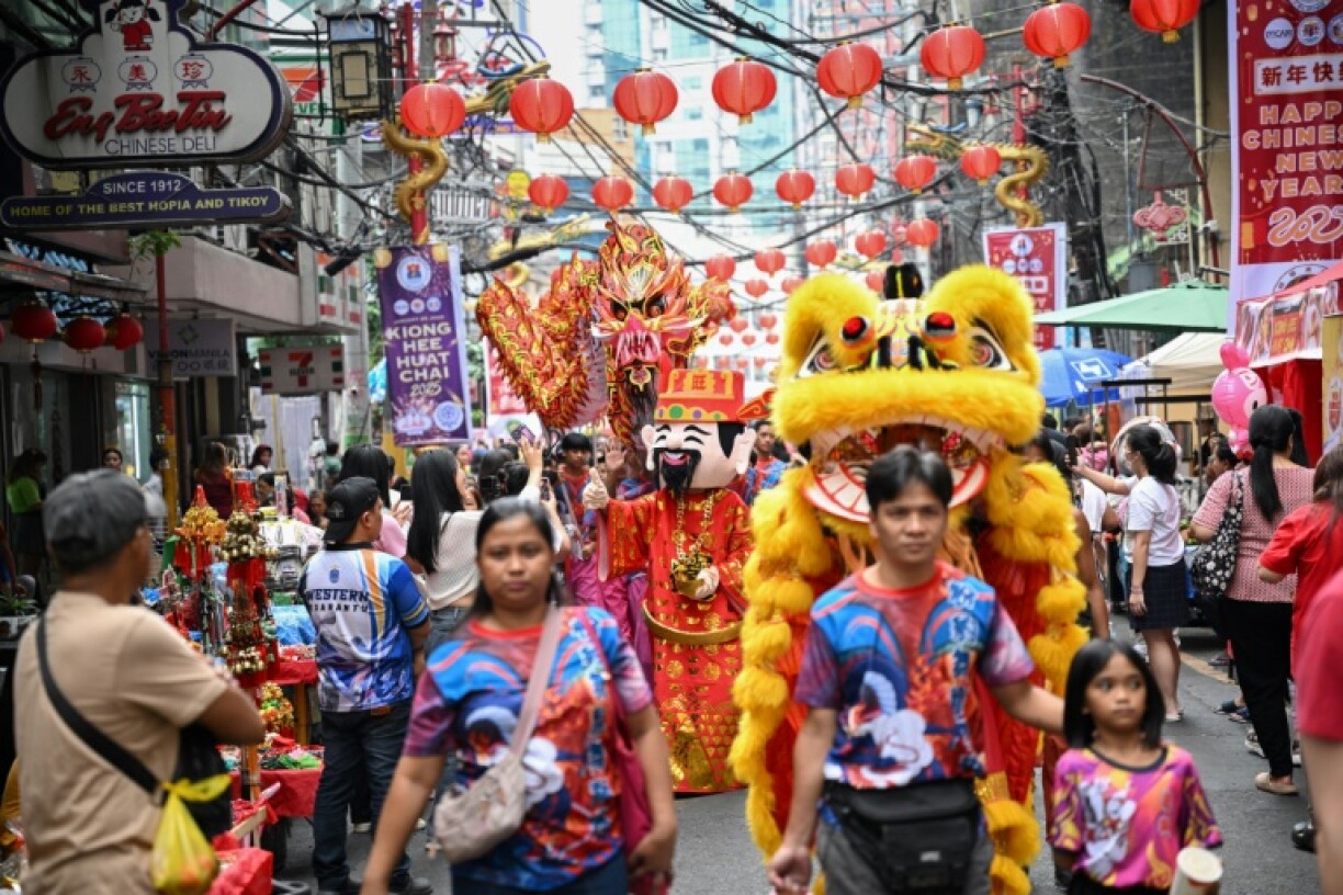 Dragon and lion dancers take part in a procession in the Chinatown district of Manila on the eve of Lunar New Year