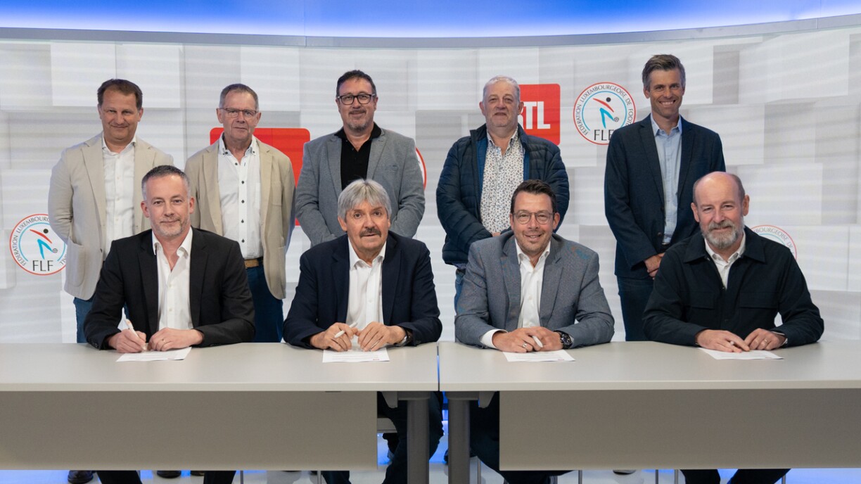 Op der Foto (1. Rei, vu lénks no riets) Claude Kremer (member du Conseil d’Administration de la FLF), Paul Philipp (President FLF), Christophe Goossens (CEO RTL Luxembourg), Steve Schmit (Content Director RTL) (2. Rei, vu lénks no riets) Pascal Casel (RTL), Erny Decker (FLF), Marc Diederich (FLF), Christian Hess (FLF), Tom Flammang (Head of Sports RTL Luxembourg)